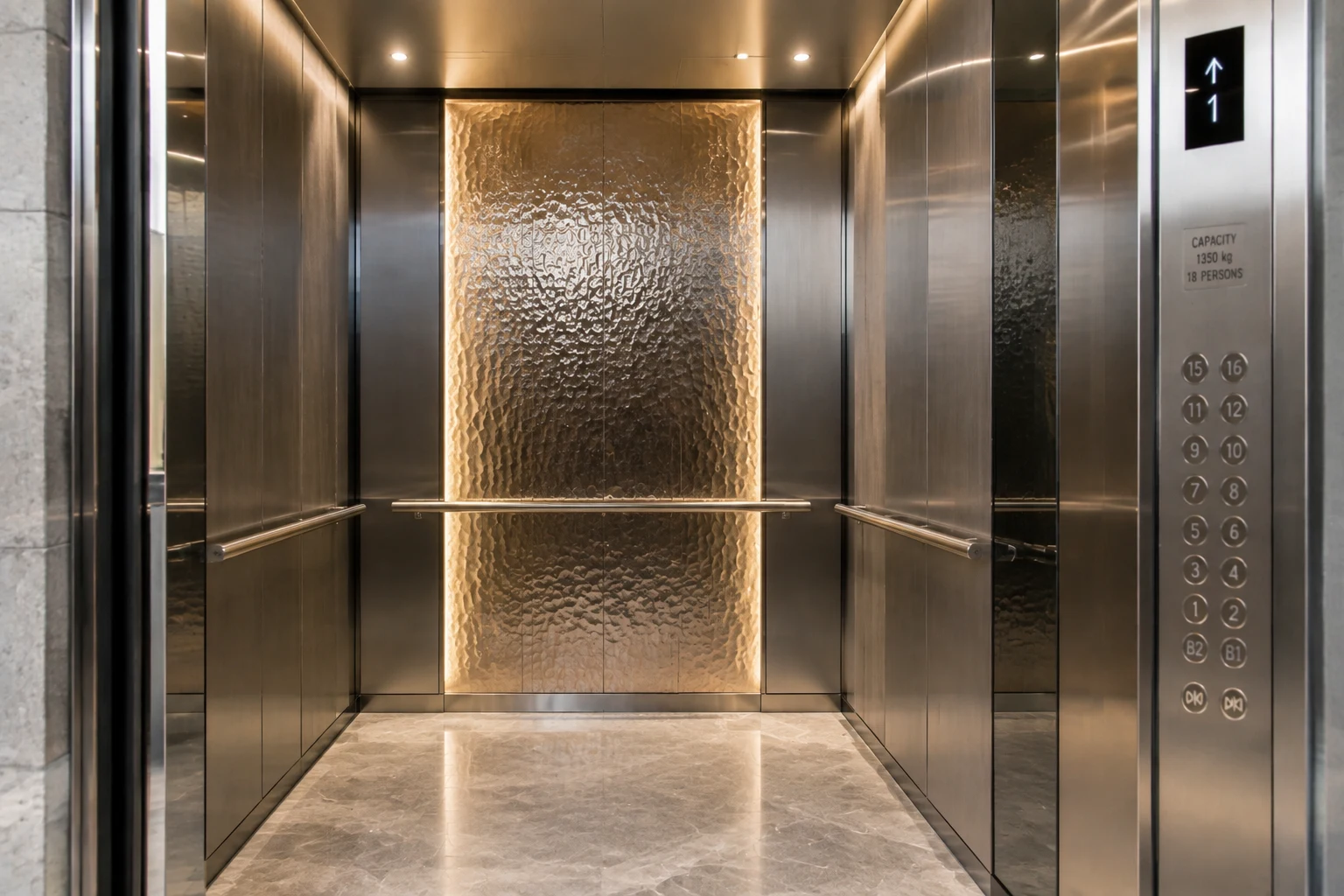 Luxury elevator interior with stainless steel wall panels and textured metal feature design